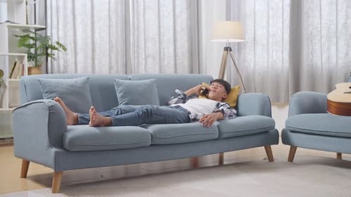 Man Relaxing on Couch and Talking on Phone