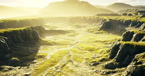 Misty Golden Hour Over Lush Green Rocky Valley