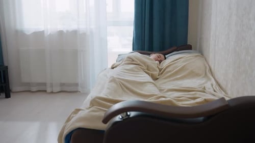 Girl Sleeping Peacefully Under Blanket in Bedroom
