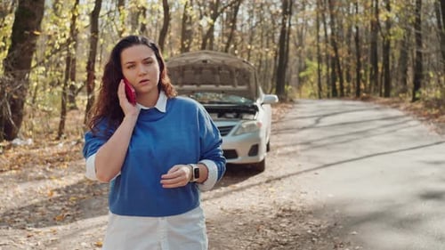 The Girl Calls the Repair Service Near the Broken Car on the Road in the Forest