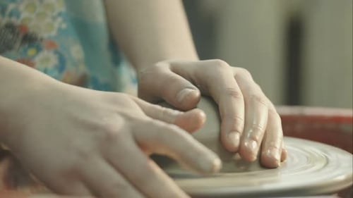 Hands Shape Clay on Potter's Wheel Close Up