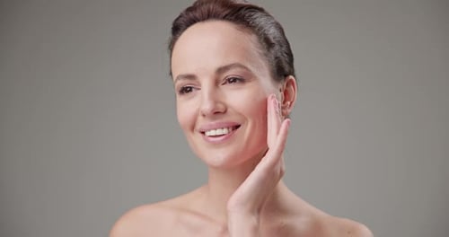 Woman Touches Her Face Gently and Smiles