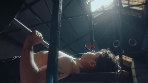 Shirtless Man Doing Barbell Bench Press during Gym Training