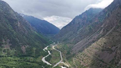 Kameraschwenk über einem Gebirgstal mit gewundenem Fluss