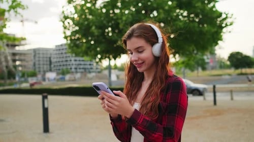 Smiling Young Woman Using Smartphone with Headphones