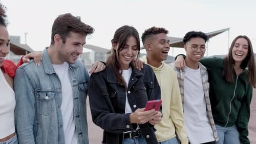Diverse Friends Smiling at Cell Phone in Urban Setting