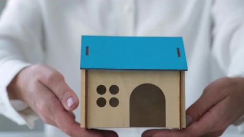 Female Hands Representing House Model Mortgage Investment Real Estate