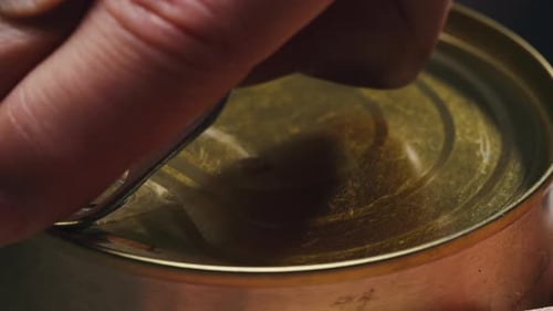 Close Up of Hands Opening a Tin Can