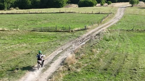Aerial Shot of a Motocross Rider on a Journey on a Dirt and Dusty Country Road Driving Fast and
