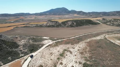 Aerial view of a car driving in Bardenas region, Spain.