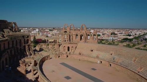 Ruines de l'amphithéâtre d'El Jem avec colonnes d'arène et murs de briques.