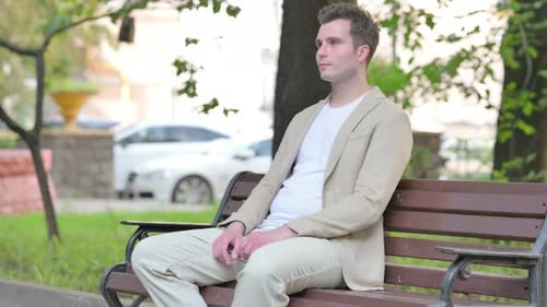 Man Relaxing on a Bench in a Park