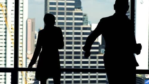 Silhouetted Colleagues Dance in Office with City View