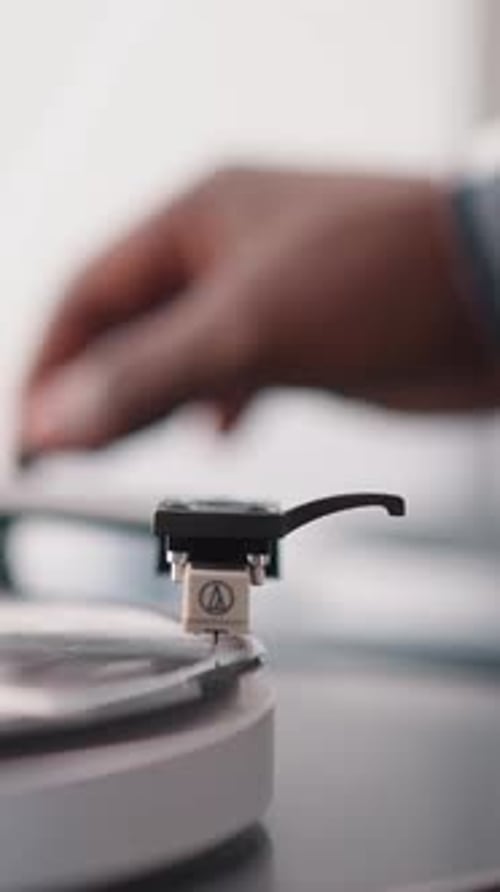 Man Puts Phono Stylus on Vinyl Disk in Turntable