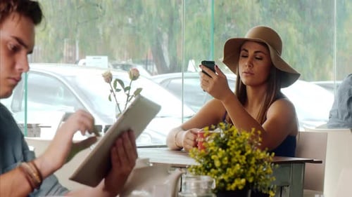 Casual Woman Using Touch Screen Mobile Phone In Cafe.