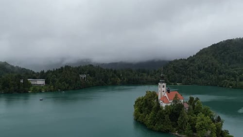 Lake Bled Slovenia reverse drone aerial view misty low clouds in background