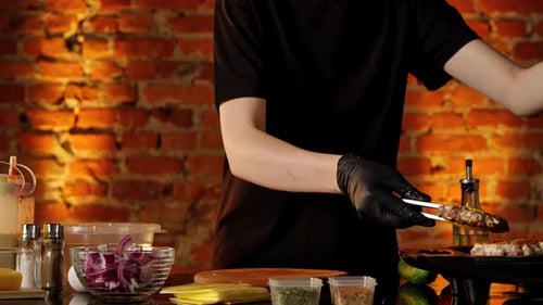 Chef Cooking Delicious Burger on Grill in Kitchen