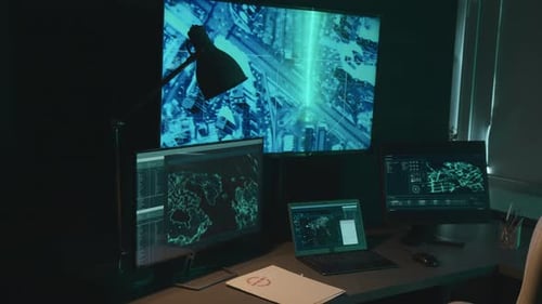 Desk with Computers Displaying Data and Maps
