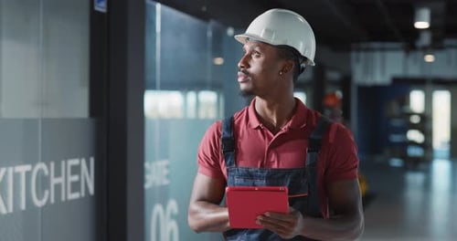 A Construction Worker Utilizing a Tablet in a Progressive and Modern Workplace Environment