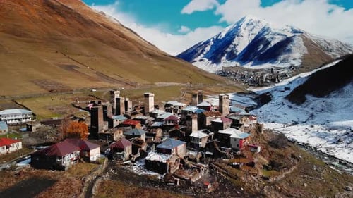 Blick von oben zeigt historische Steintürme und enge, gewundene Pfade