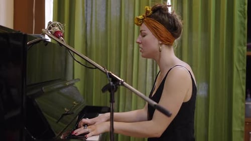 Woman Plays Piano and Sings into Microphone