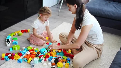 Child and Adult Playing With Building Blocks at Home