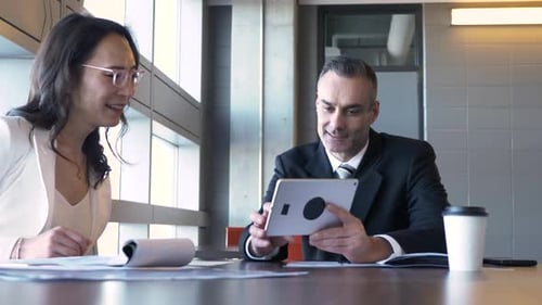 Business people discussing plans using digital tablet in modern office