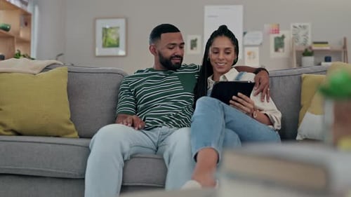 Couple Relaxing on Couch Watching Tablet