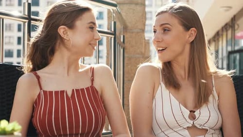 Two Young Women Talking and Smiling Outside