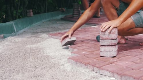 The Builder is Laying Paving Stones