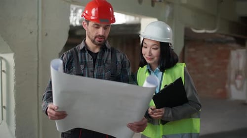 Engineers Reviewing Plans at Construction Site
