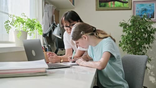 Girl Studies with Mother at Desk at Home