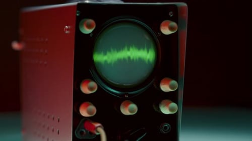 Osciloscópio com iluminação colorida exibindo a forma de onda verde que muda rapidamente