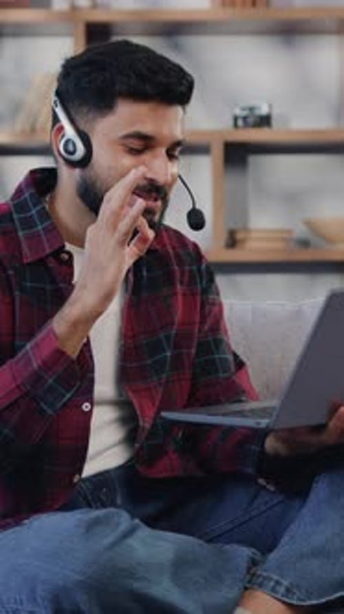 Young Man Talking on Laptop Wearing Headset
