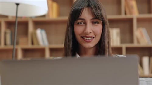 Woman Smiling at Laptop at Home in Daytime