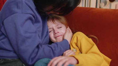 Nahaufnahme von Sad Girl Kid weint und lügt Mutter zu Hause Gewalt gegen Kinder in der Familie