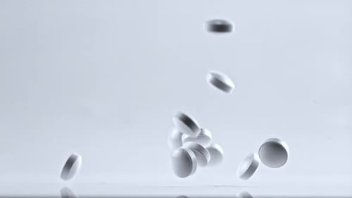 Pills Fall on the Table Filmed is Slow Motion 1000 Frames Per Second