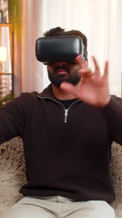 Man Using VR Headset Sitting on Sofa