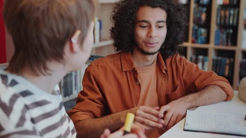 Middle Eastern Student Chatting with Female Group Mate in Library