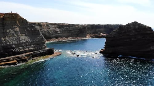 Isolated Coastal Shelter Surrounded By Limestone Cliffs And Vibrant Turquoise Aquatic Scenery Media
