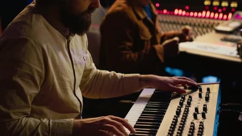 Musician Artist Playing Midi Controller Synthesizer in Recording Music Studio