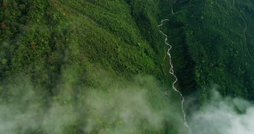 Atmospheric Aerial View of Mountain Waterfall Surrounded by Tropical Fog
