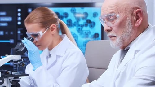 Researchers Analyze Data Using Microscope in Laboratory