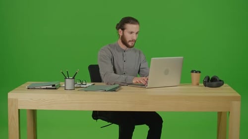 Man Works at Desk on Laptop Green Screen