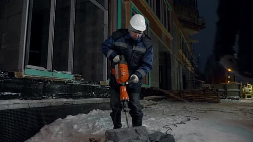 Construction Worker Using Jackhammer at Night