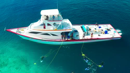 Fishermen on a White Boat Take Out Fishing Nets with Caught Fish Near a Local Island Ukulhas in the