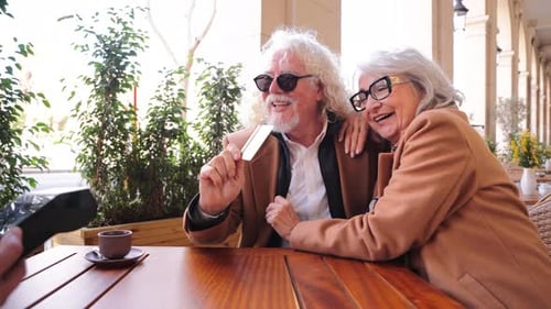 Senior Couple Paying Bill at Outdoor Cafe