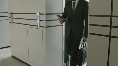 Businessman Going Out of Panoramic Office Elevator
