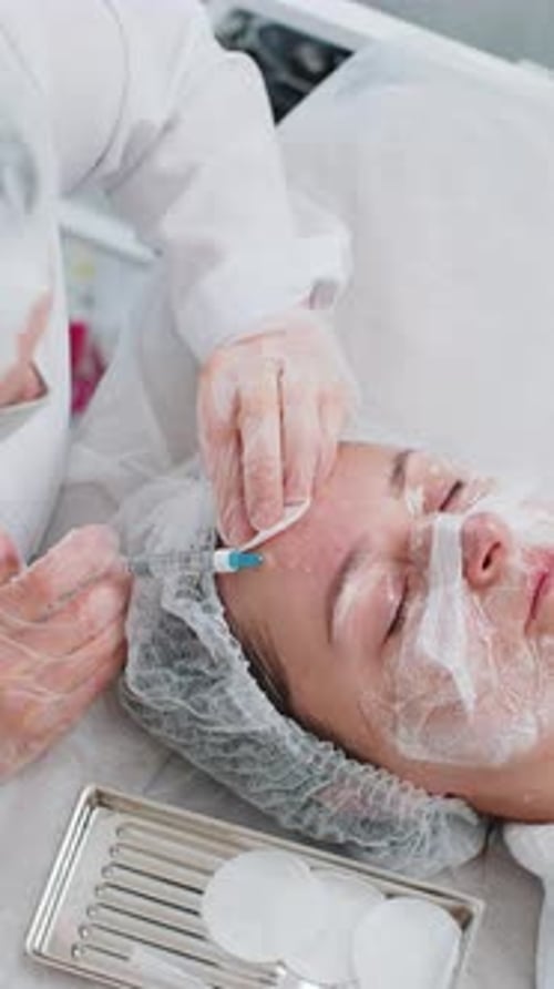 Kosmetikerin macht junge Frau Schönheit Anti-Aging-Injektionen Biorevitalisierung Gesichtsmesotherapie
