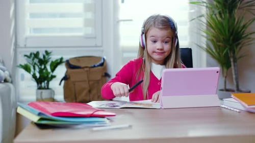 Girl Using Tablet at Desk for Online Learning